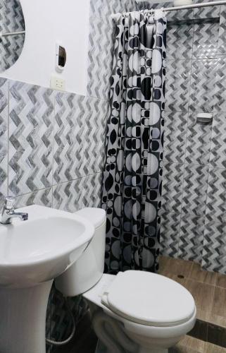 a bathroom with a toilet and a shower curtain at Hospedaje Aqquazul Ayacucho in Ayacucho