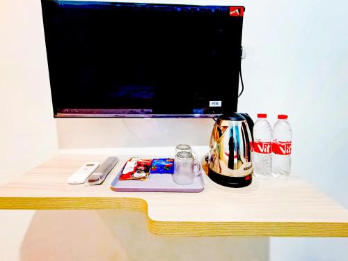 a table with a coffee pot and soda bottles at RedDoorz near Candi Prambanan 3 Yogyakarta in Kenaran