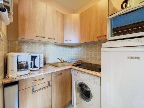 une cuisine avec une machine à laver et un évier dans l'établissement Studio 4 pers au pied des pistes avec balcon à La Toussuire - FR-1-416-236, à La Toussuire