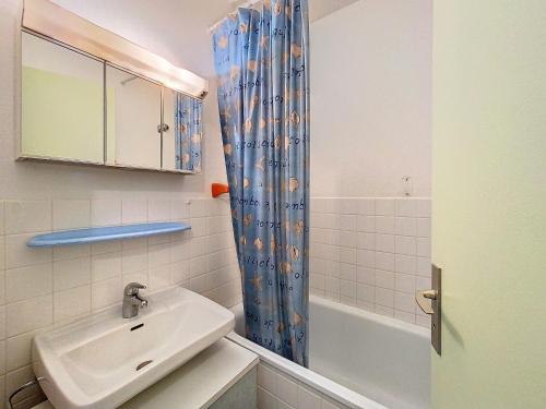 une salle de bain avec un lavabo et un rideau de douche dans l'établissement Studio 4 pers au pied des pistes avec balcon à La Toussuire - FR-1-416-236, à La Toussuire