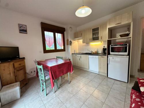 - une cuisine avec une table et une serviette rouge dans l'établissement Villard Village - Appartement 6 pers, 35 m² - FR-1-515-226, à Villard-de-Lans