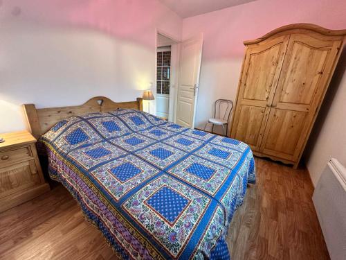 a bedroom with a bed and a wooden cabinet at Villard Village - Appartement 6 pers, 35 m² - FR-1-515-226 in Villard-de-Lans