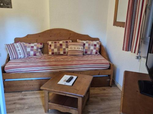 un lit avec des oreillers et une table dans une chambre dans l'établissement Appartement T2 avec Terrasse et Parking à Cauterets - FR-1-234-337, à Cauterets