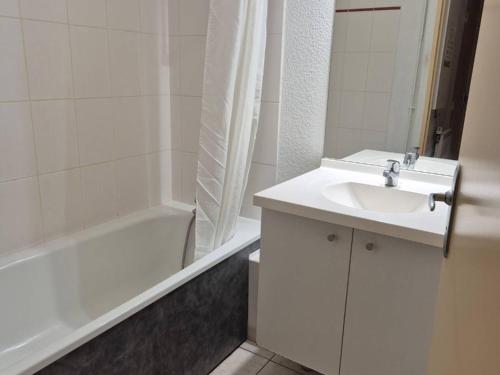 une salle de bain blanche avec un lavabo et une baignoire dans l'établissement Appartement T2 avec Terrasse et Parking à Cauterets - FR-1-234-337, à Cauterets