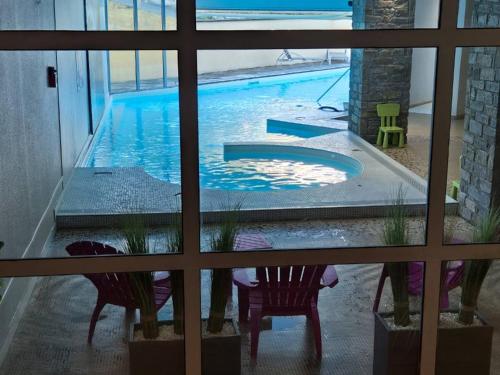 une vue d'une piscine à travers une fenêtre dans l'établissement Appartement T2 avec Terrasse et Parking à Cauterets - FR-1-234-337, à Cauterets