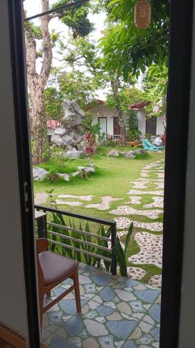 a door open to a yard with a chair and a house at Tran Chau Garden Home in Cat Ba