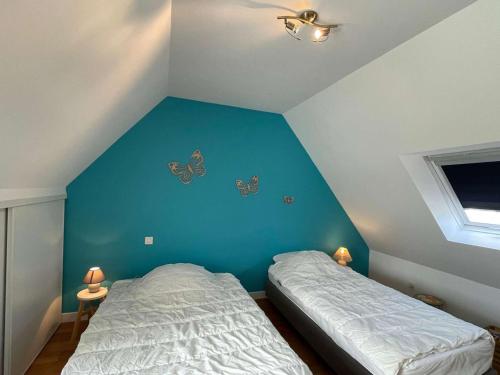 - une chambre avec un mur bleu et 2 lits dans l'établissement Maison 3 étoiles rénovée 2025, terrasse, accueil animaux, bord de mer - FR-1-542-71, à Pleumeur-Bodou