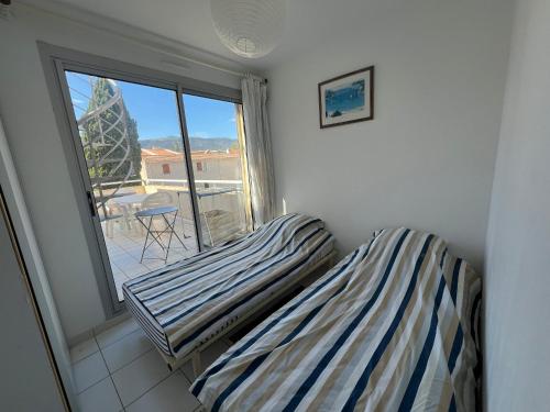 une chambre avec un lit et un balcon avec vue dans l'établissement Appartement T3 à Argelès-sur-Mer avec Terrasse et Parking - FR-1-309-509, à Argelès-sur-Mer