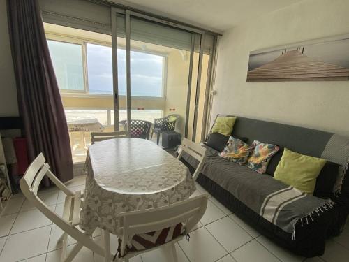 un salon avec un canapé et une table dans l'établissement Deux-Pièces 4 pers. Face Mer, Canet-Plage - FR-1-750-98, à Canet