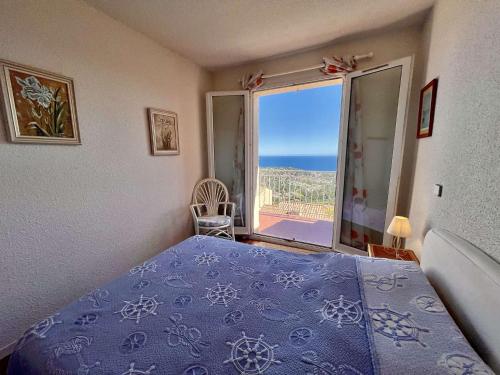 - une chambre avec un lit bleu et une vue sur l'océan dans l'établissement Appartement 2 Pièces - Vue Mer - Piscine - Cavalaire - FR-1-226B-237, à Cavalaire-sur-Mer