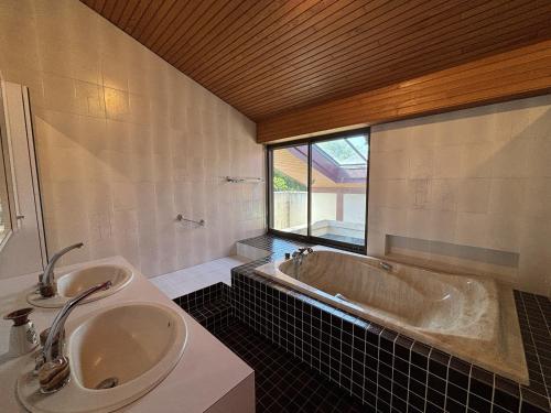 une salle de bain avec une baignoire et un lavabo dans l'établissement Maison Landaise d'Architecte - 8 Pers - Biscarrosse Bourg - FR-1-319-609, à Biscarrosse