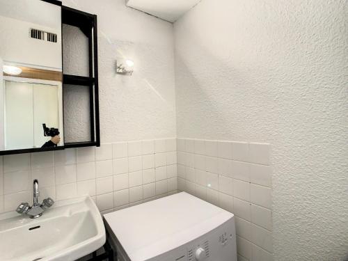 une salle de bain blanche avec un lavabo et un miroir dans l'établissement Charmant appartement à La Toussuire, 5 pers, près des pistes - FR-1-416-235, à La Toussuire