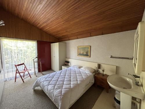 une chambre avec un grand lit et un lavabo dans l'établissement Maison Landaise d'Architecte - 8 Pers - Biscarrosse Bourg - FR-1-319-609, à Biscarrosse