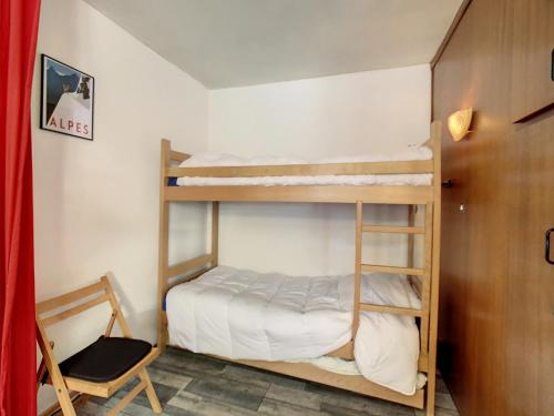- une chambre avec 2 lits superposés et une chaise dans l'établissement Studio lumineux pour 4 à La Toussuire - FR-1-416-237, à La Toussuire