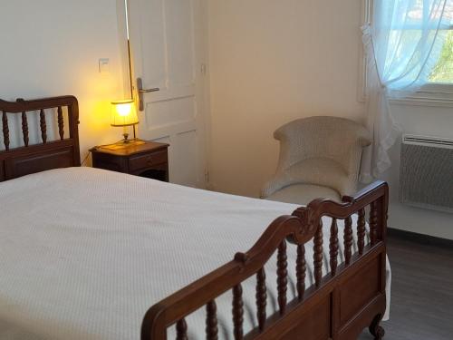 une chambre avec un lit, une chaise et une lampe dans l'établissement Maison spacieuse à Capbreton, proche port et plages, jusqu'à 6 personnes - FR-1-239-1122, à Capbreton