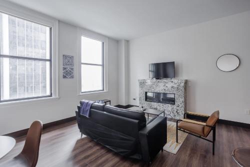 a living room with a couch and a fireplace at CozySuites Sky Central #6 in Cincinnati