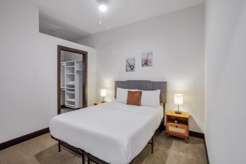 a bedroom with a large white bed and two lamps at CozySuites Sky Central #6 in Cincinnati