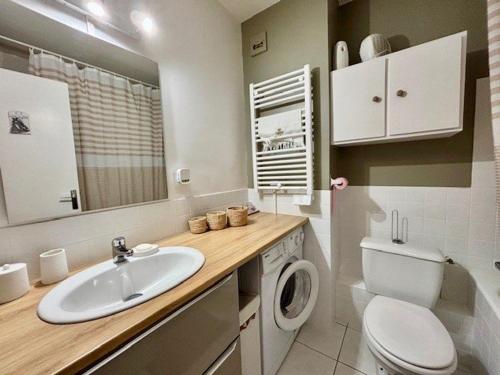 une salle de bain avec un lavabo et une machine à laver dans l'établissement Studio lumineux 28m² - Vue mer - Parking - Petits animaux acceptés - FR-1-478-318, à Quiberon