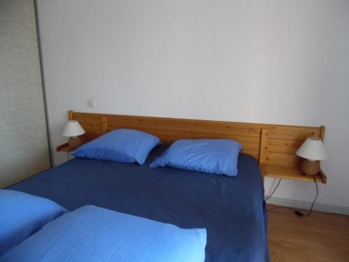 une chambre avec un lit avec deux oreillers bleus dans l'établissement Appartement traversant 2 pièces, 4 pers, loggias, parking, proche plage - FR-1-750-97, à Canet
