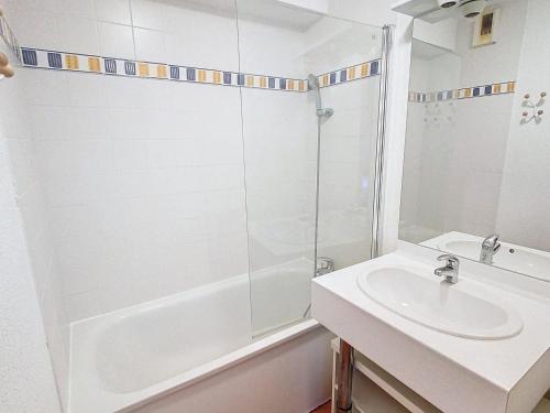 une salle de bain blanche avec une douche et un lavabo dans l'établissement Spacieux T3 lumineux à La Toussuire, 6 pers, parking et piscine en été - FR-1-416-234, à La Toussuire