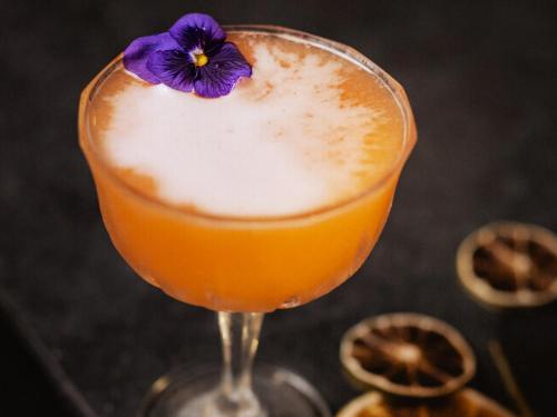 a drink with a purple flower in a glass at Grand Sirenis Riviera Maya Resort & Spa All Inclusive in Akumal