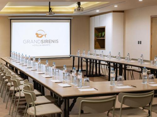 a large room with tables and chairs and a projector screen at Grand Sirenis Riviera Maya Resort & Spa All Inclusive in Akumal