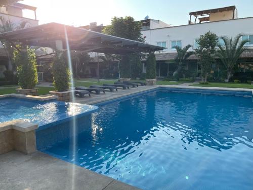 a swimming pool with a fountain in front of a building at Sweet and Family home!! in Xochitepec