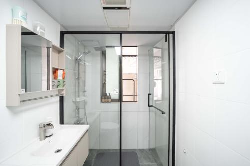 a bathroom with a glass shower and a sink at Shanghai Yi Du B&B - Family Suite 500m to Nanjing West Rd Near People's Square -Credit Cards Accepted in Shanghai