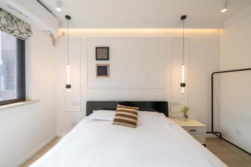 a bedroom with a white bed and a window at Shanghai Yi Du B&B - Family Suite 500m to Nanjing West Rd Near People's Square -Credit Cards Accepted in Shanghai