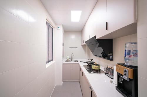 a white kitchen with a sink and a stove at Shanghai Yi Du B&B - Family Suite 500m to Nanjing West Rd Near People's Square -Credit Cards Accepted in Shanghai