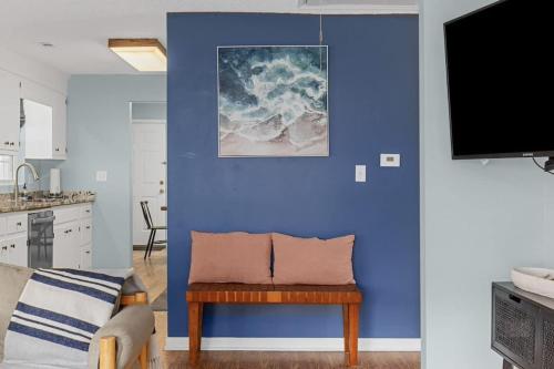 a living room with a blue wall with a bench and a tv at *COMFY N. MYRTLE HOUSE*3 NEW Queens*Steps to the Beach*V384 in Myrtle Beach
