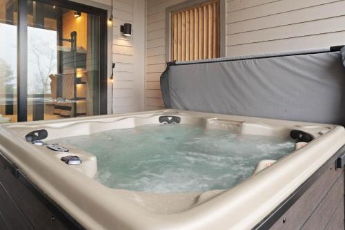 un jacuzzi en un baño con ventana en Blue Ridge Bliss, en Boone