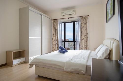 ein Schlafzimmer mit einem weißen Bett mit einem Fenster in der Unterkunft Marina Court Yr 1st Choice Family Aparment-Stay And Get Cash Rebate in Kota Kinabalu
