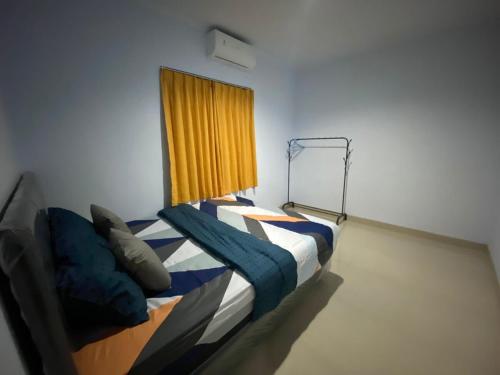 a bedroom with a bed with a yellow curtain at Djanuraga House 6 in Darmasaba