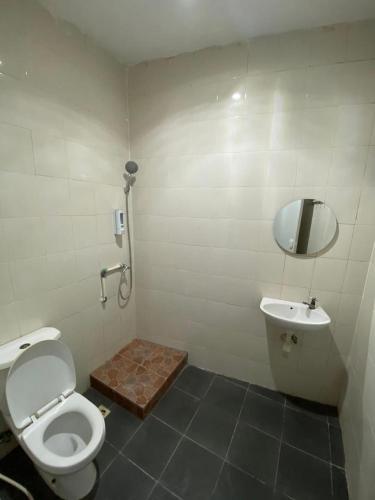 a bathroom with a toilet and a sink and a mirror at Djanuraga House 6 in Darmasaba