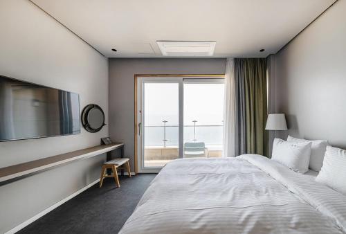 a bedroom with a large bed and a large window at Daynice hotel in Boryeong