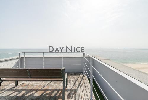 a bench sitting on a boardwalk next to the ocean at Daynice hotel in Boryeong