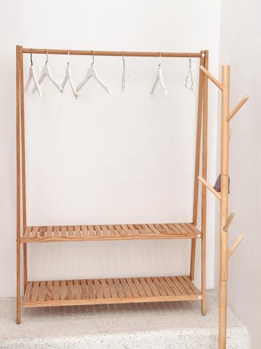 a wooden shelf with four hangers on a white wall at Santorini Villa Cam Ranh in Cam Ranh
