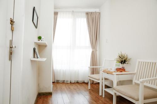 a living room with a table and chairs and a window at Saigon's Book Da Lat Hotel in Da Lat