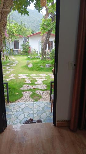 an open door to a patio with a view of a yard at Tran Chau Garden Home in Cat Ba