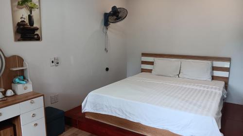 a bedroom with a bed and a clock on the wall at Tran Chau Garden Home in Cat Ba