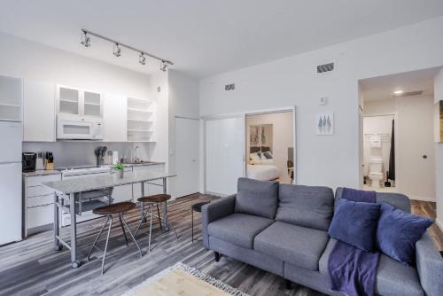 a living room with a couch and a kitchen at CozySuites Sky Central #9 in Cincinnati
