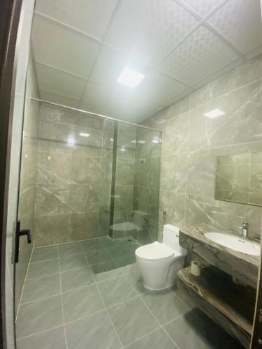 a bathroom with a shower and a toilet and a sink at Phòng lưu trú du lịch nhà phố trung tâm in Ða Gia