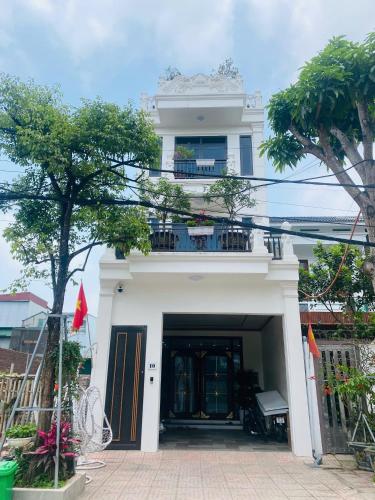 a white house with a balcony on top of it at Phòng lưu trú du lịch nhà phố trung tâm in Ða Gia