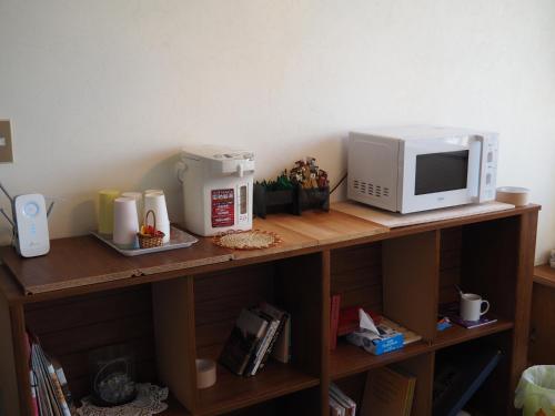 a counter with a microwave and a coffee maker on it at 北軽井沢 あさま1155 in Tsumagoi