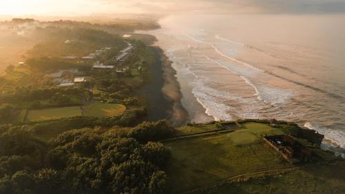 an aerial view of a golf course and the ocean at Soori Bali in Tabanan