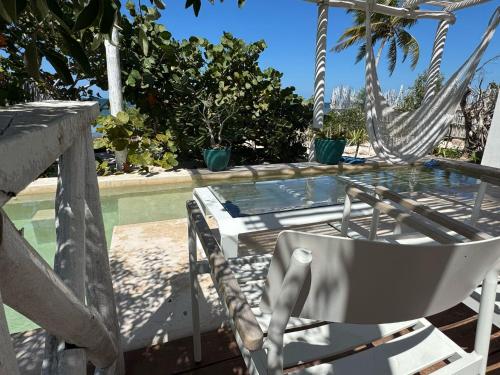 a hammock and a table and a chair next to a pool at Casa Arsha Beachfront Bed & Breakfast in Dzidzantún