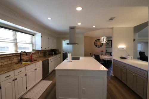 a large kitchen with white cabinets and a large island at 4bed, 2bath cozy-luxury-modern house in Grand Prairie