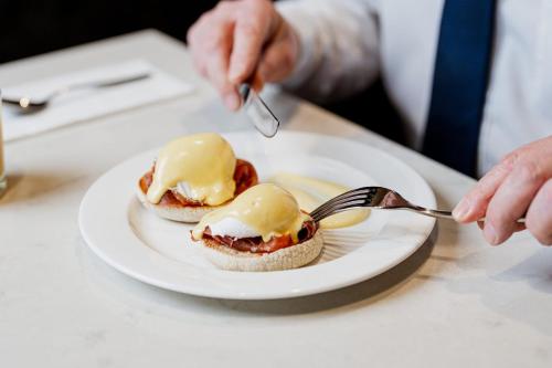 a person eating food on a plate with a spoon and fork at Crowne Plaza Aberdeen Airport by IHG in Dyce