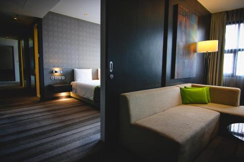 a hotel room with a couch and a bed at Holiday Inn Bangkok Sukhumvit by IHG in Bangkok